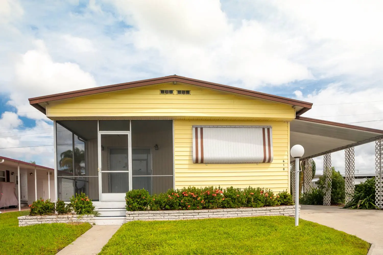 Yellow prefab ADU with flat roof and modern lawn