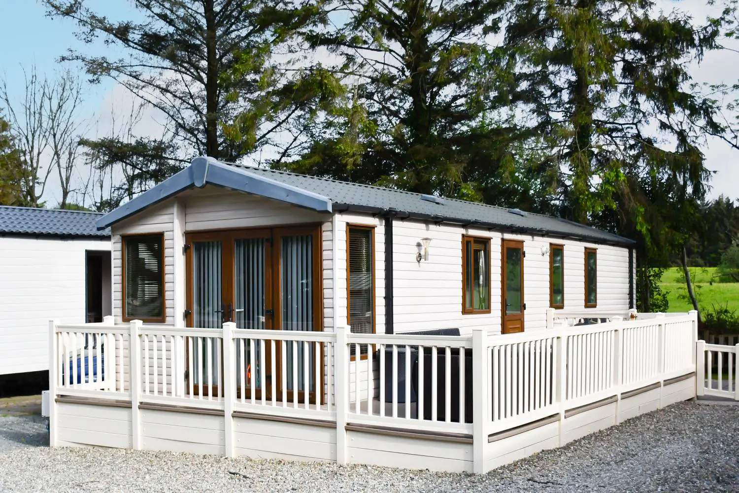 Compact ADU tiny home with porch and white fencing